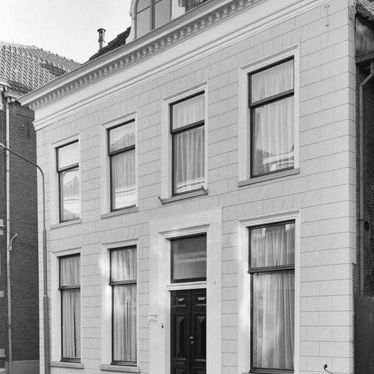 Pand onder schilddak en met in de 19e eeuw gepleisterde lijstgevel, die echter twee ankers uit de bouwtijd van het pand in de bovenhoeken bewaard heeft