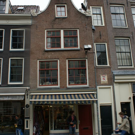 Pand met ingezwenkte halsgevel waarnaast smalle travee waarin gevelsteen met wapen en