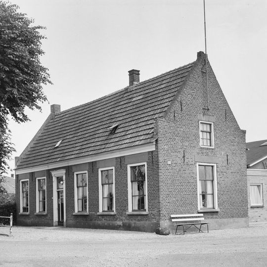 Dorpswoning, onder zadeldak tussen zijtopgevels; omlijste ingang