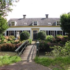 Pand zonder verdieping breed pand, met bepleisterde lijstgevel gekeerd naar de weg