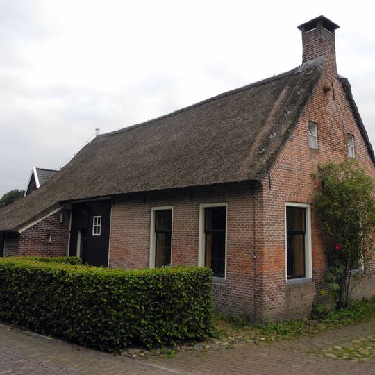Kleine boerderij met woondeel met topgevel met vlechtingen en hoekschoorstenen