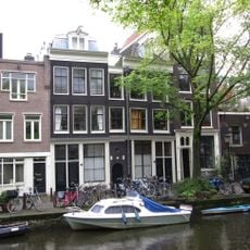 Huis met rechte lijst, dat ter linker zijde boven een thans afgesloten gang is overgebouwd
