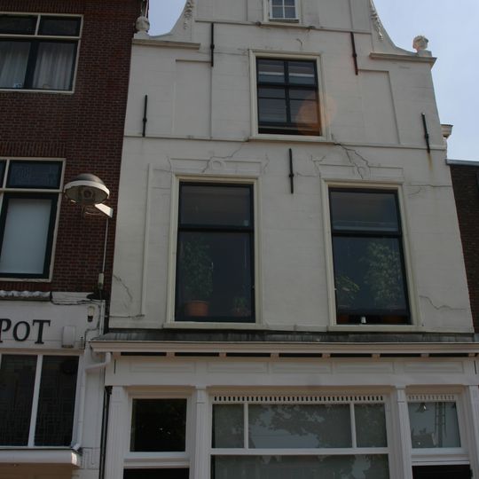 Pand met gepleisterde trapgevel met zandstenen vleugelstukken, festoenen en vazen