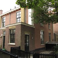 Blok van vier rug-aan-rug gebouwde woningen op vierkante plattegrond, bestaande uit begane grond en verdieping onder een plat dak