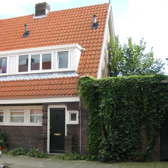 Blok met 8 keukenwoningen, zo genoemd vanwege destijds nieuwe plaatsing van keuken aan de voorzijde, aan de zijkant een houten topgevel, bouwstijl Amsterdamse School.