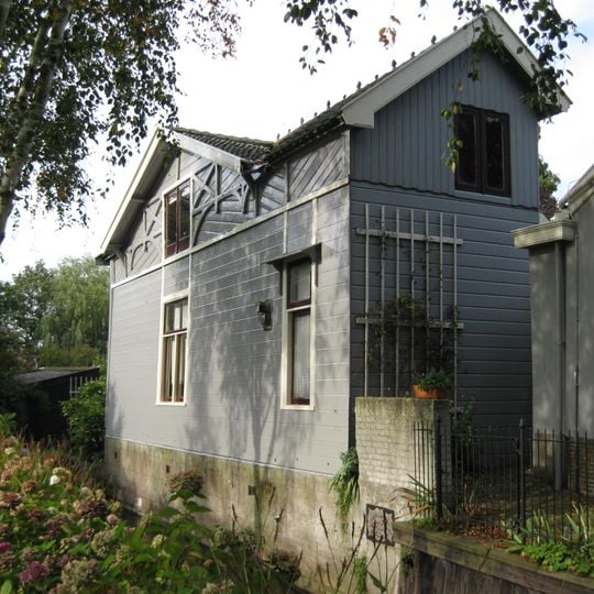 Houten theehuis met ten dele versierde daklijst en openslaande deuren met luiken