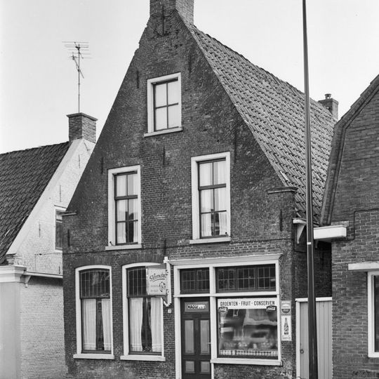 Pand onder zadeldak tussen topgevels met top met lijsten en zes- en vierruitsvensters