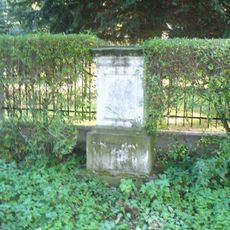 Podstavec ulomeného kříže u plotu zahrady domu 27 v Kerharticích