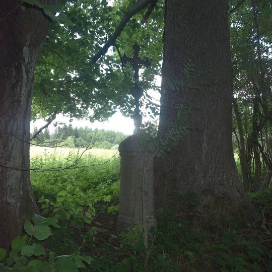 Kříž nad Šibanovem mezi stromy