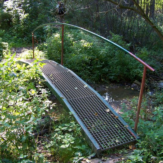 Lávka červeně značené trasy přes potok od rybníka Plocko