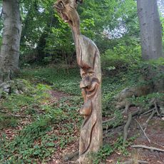 Holzskulptur eines Gesichts in einem Baumstamm