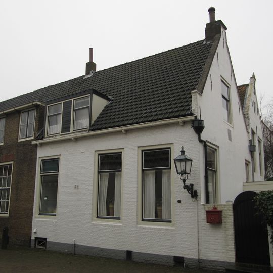 Pand met gecementeerde puntgevel met gevelsteen