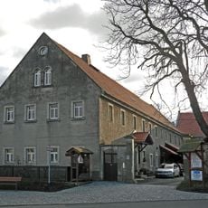 Dreiseithof mit Wohnstallhaus, Scheune und Seitengebäude, dazu Hofmauer mit zwei Torpfeilern und Pforte Dorfplatz 5