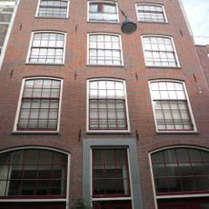 Pak- of werkhuis met tamelijk sterk getoogde vensters waarin een goede roedenverdeling