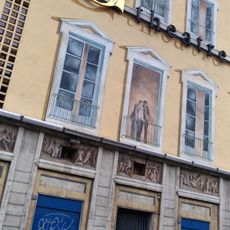 Série de fenetres dessinées en trompe-l'oeil sur le mur aveugle du théatre municipal