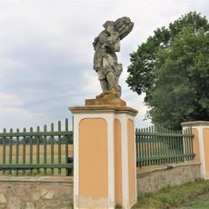 Alegorická socha Zima v ohradě zámecké zahrady ve Veltrusech