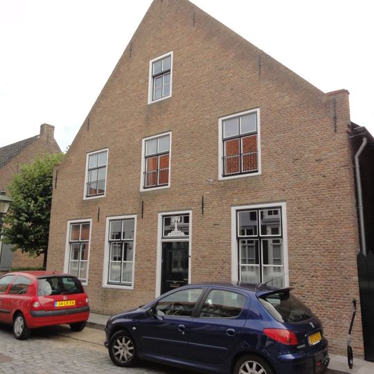 Huis onder groot zadeldak, boven de voorgevel afgewolfd