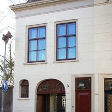 Huis met gepleisterde lijstgevel met inrijpoort