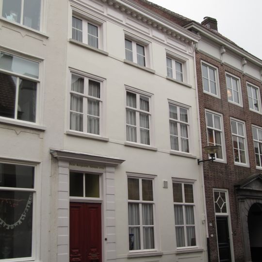 Huis met gepleisterde empire gevel, kroonlijst op klossen, ingang met geblokte pilasters