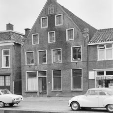 Fors pand met verdieping en twee zolders onder diep zadeldak tegen puntgevel