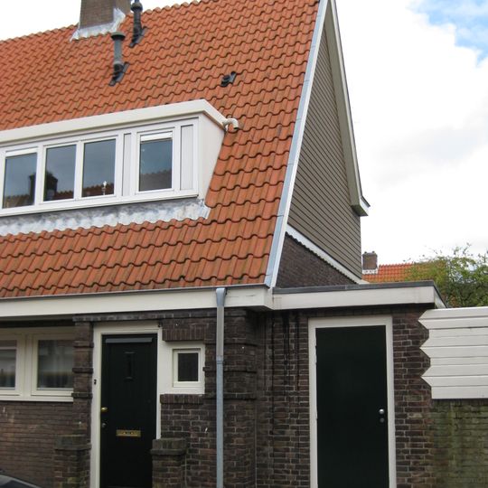 Blok met 8 keukenwoningen, zo genoemd vanwege destijds nieuwe plaatsing van keuken aan de voorzijde, aan de zijkant een houten topgevel, bouwstijl Amsterdamse School.