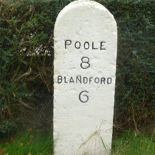 Milestone, Blandford Road, 160m N of cross-roads with Station Rd, in front of Burton Lux