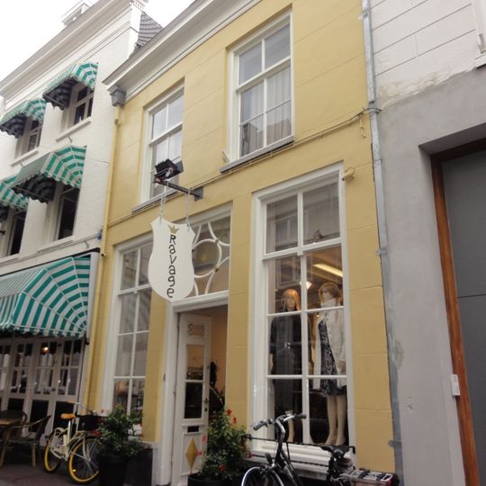 Huis met lijstgevel met versierde ingangspartij met gesneden bovenlicht en deur