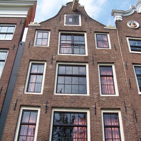 Pand met 18e-eeuwse gevel onder 19e-eeuwse klokvormige top met rollagen