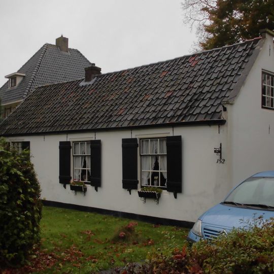 Laag gepleisterd huis in topgevel eindigend