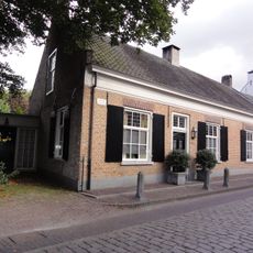 Huis onder dwars zadeldak tussen zij-topgevels