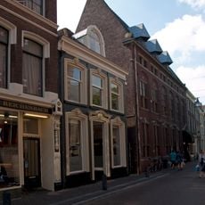 Pand met lijstgevel met dakkapel, gepleisterde raam- en deuromlijstingen met versierde boogbeeindigingen en gepleisterde plint met panelen