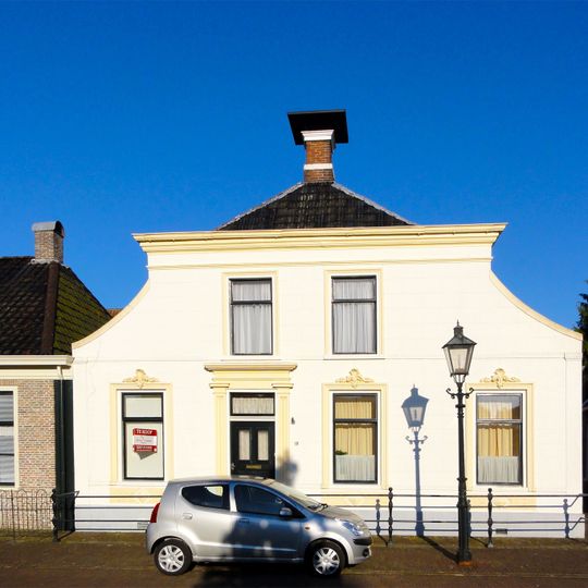 Pand onder zadeldak met wolfseind boven ingezwenkte gepleisterde voorgevel