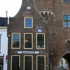 Pandje met klokgevel en zandstenen gebeeldhouwde halfronde topafdekking en aanzetvoluten