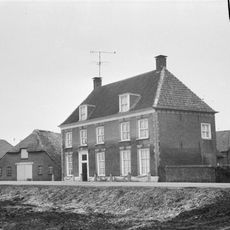 Herenhuis met verdieping en hoog schilddak, waarop hoekschoorstenen