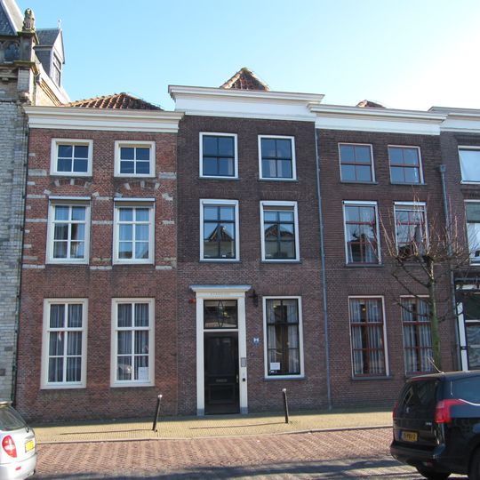 Pand met afgeknotte en door en houten lijst afgedekte trapgevel