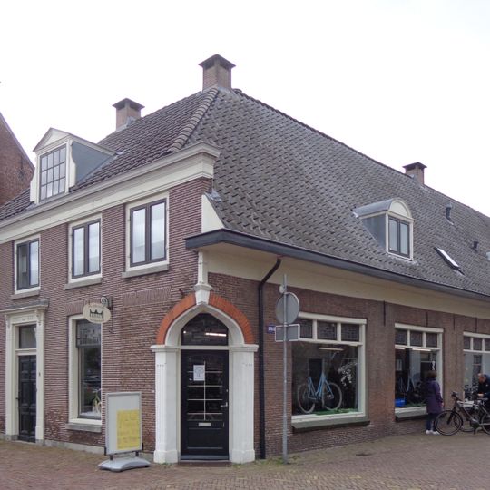 Pand met lage gevel met rechte kroonlijst, deels verbouwd