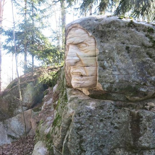 Skalní reliéf Troll u lesní cesty v Brništi
