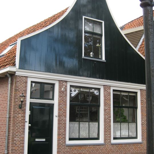 Huis met houten topgevel. Oorspronkelijk kozijnen