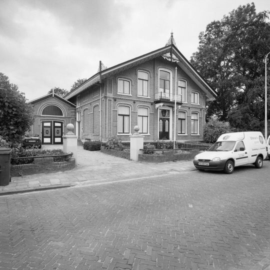 Woonhuis met praktijkruimte en aangebouwd koetshuis in ambachtelijk-traditionele stijl met Chaletstijl-invloeden