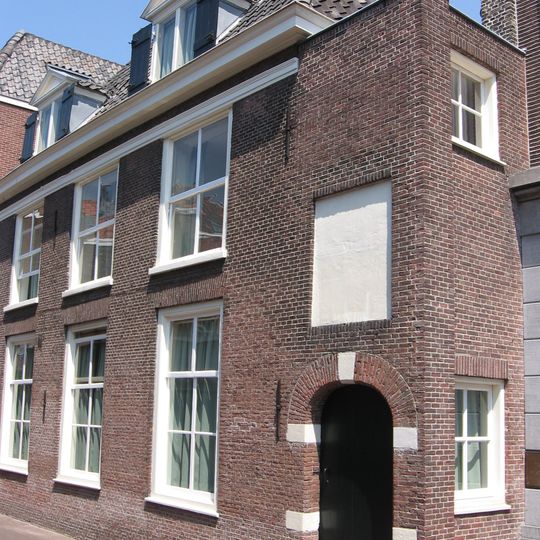 Gebouw van parterre en verdieping met hoog, dwars schilddak, waarin twee dakkapellen met frontons. Eenvoudige lijstgevel van vier vensterassen met zes- en vierruitsschuiframen.