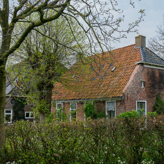 Grote kop-hals-rompboerderij met voorhuis met afgewolfde topgevel