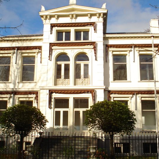 Herenhuis, met gepleisterde gevels en hoger opgetrokken middenpartij, bekroond door een fronton