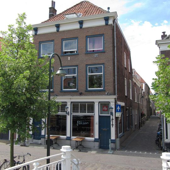 Hoekpand Vissteeg van parterre en twee verdiepingen onder hoog schilddak. Lijstgevel met gesneden Lod. XIV-consoles in de kroonlijst