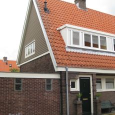 Blok met 8 keukenwoningen, zo genoemd vanwege destijds nieuwe plaatsing van keuken aan de voorzijde, aan de zijkant een houten topgevel, bouwstijl Amsterdamse School.