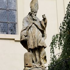 Socha svatého Ambrože na ohradní zdi kostela v Lysé nad Labem