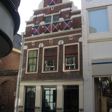 Bakstenen trapgevel waarin natuurstenen sierdelen ruim verwerkt zijn