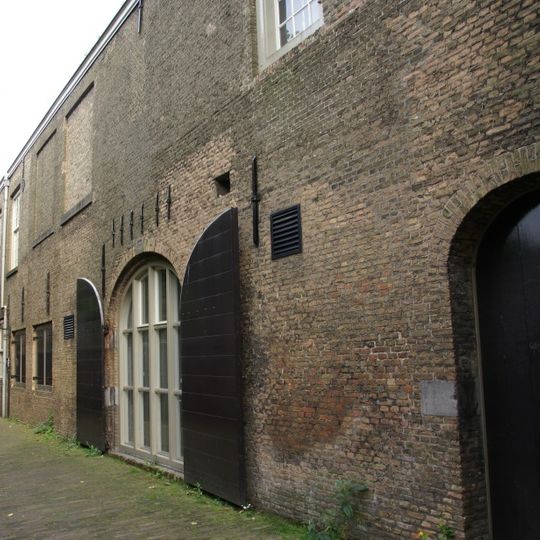 Groot pakhuis ter breedte van twaalf vensterassen, toegankelijk door twee getoogde poorten