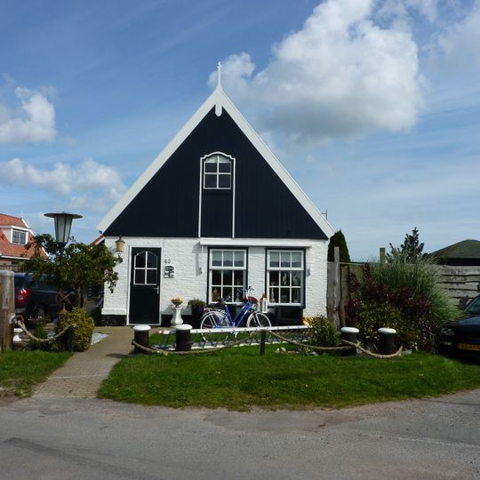 Woonhuis onder zadeldak tegen houten voorschot met getoogd luik