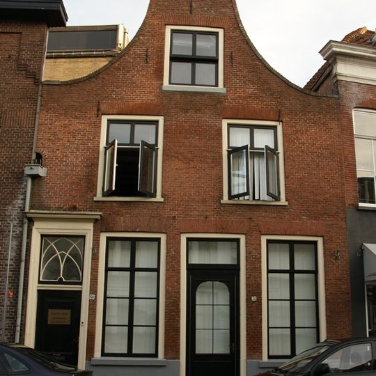Huis met gaaf bewaarde tuitgevel met deur, voorzien van klopper en neo-gotisch bovenlicht