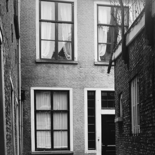 Pand met maskersteen in de gevel onder zadeldak met schild, topschoorsteen en dakkapel